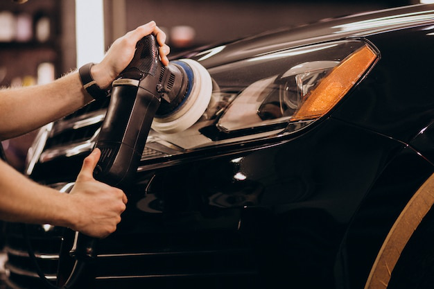 A car detailer polishing a car