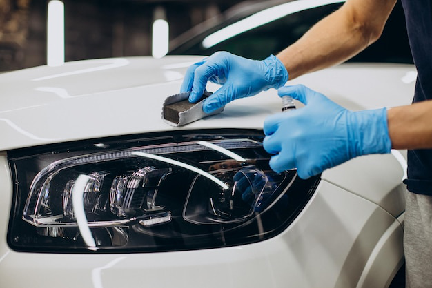 A person applying ceramic coating to a car